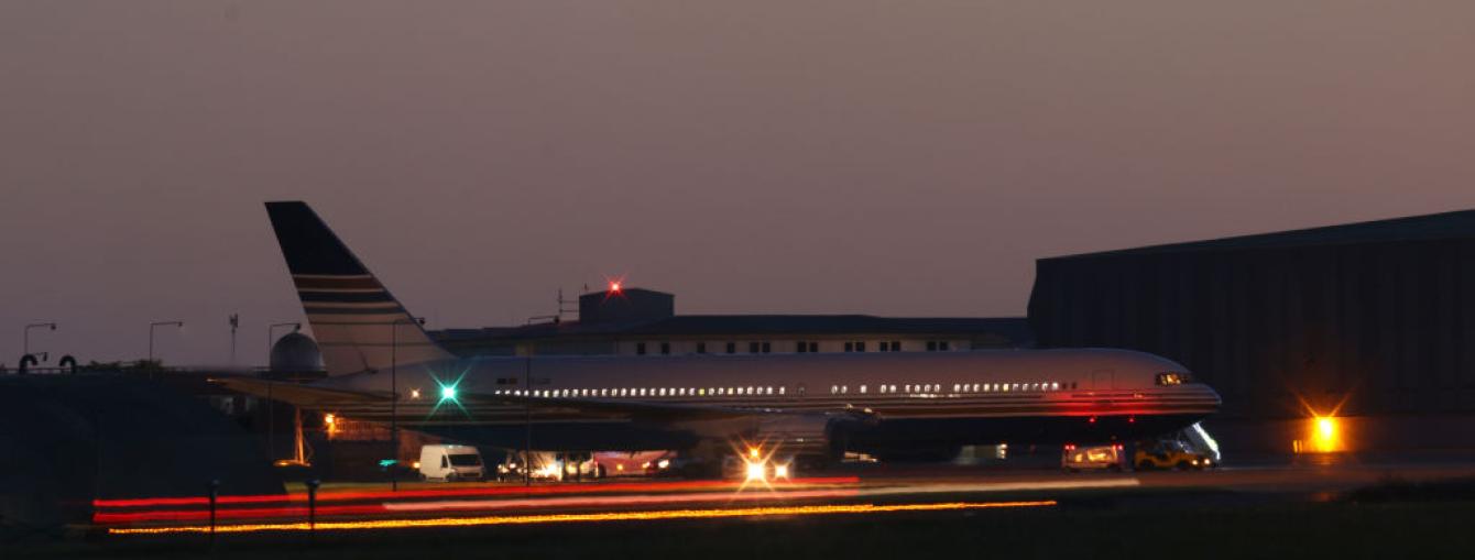 A plane on a runway, in the nighttime