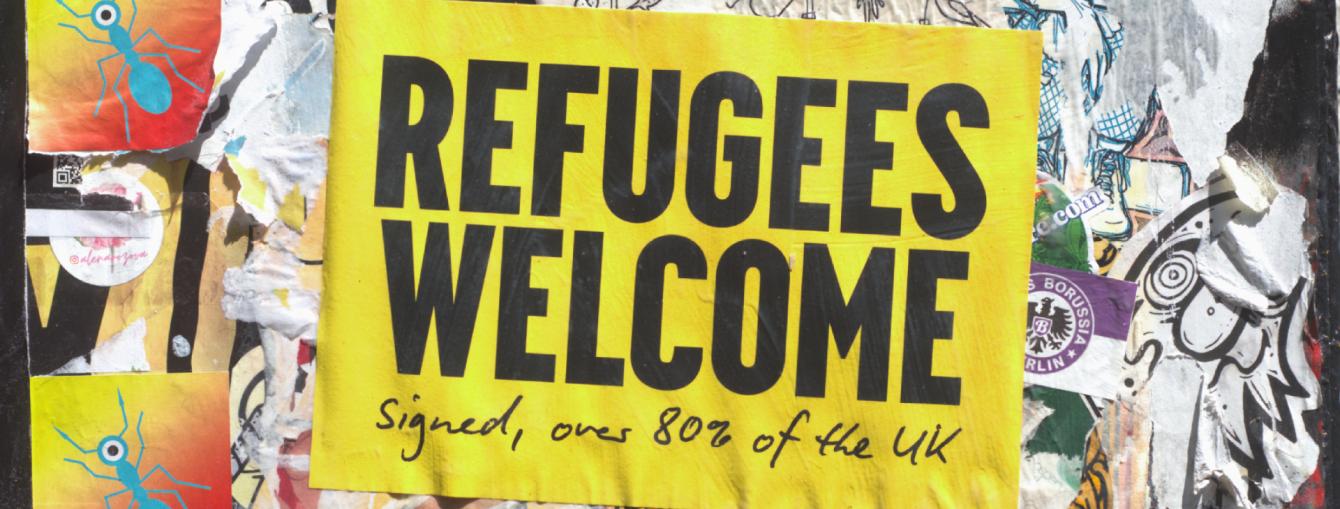 Poster on a wall that says 'Refugees Welcome'