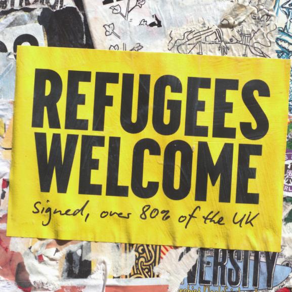 Poster on a wall that says 'Refugees Welcome'