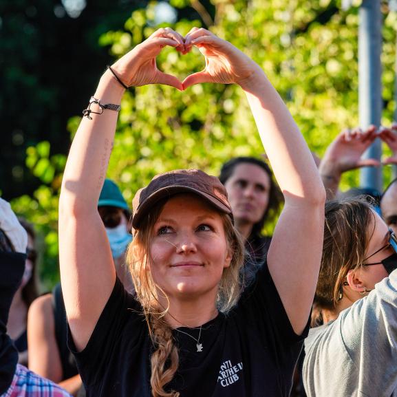 A protester makes a heart with her hands to show her love to asylum seekers