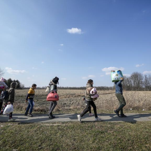 Group of people walking, carrying belongings