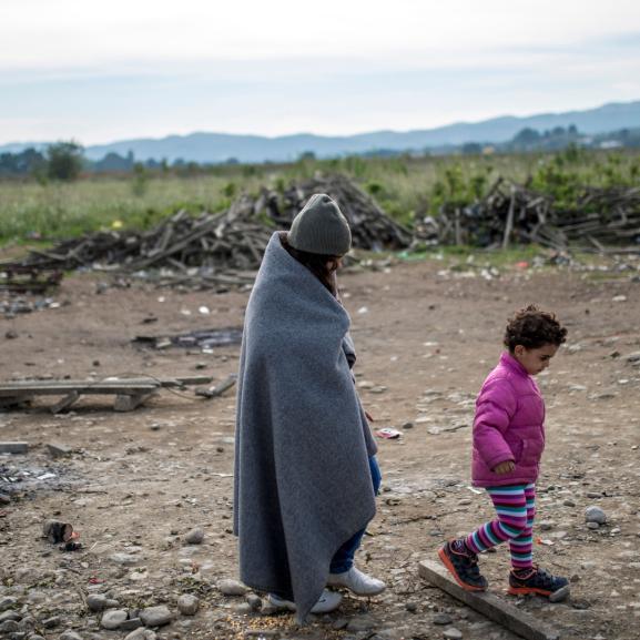 Woman and child walking along dry land