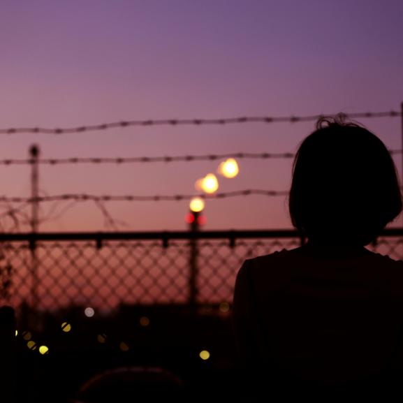 Silhouette of Person in Front of Fence