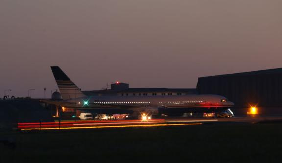 A plane on a runway, in the nighttime