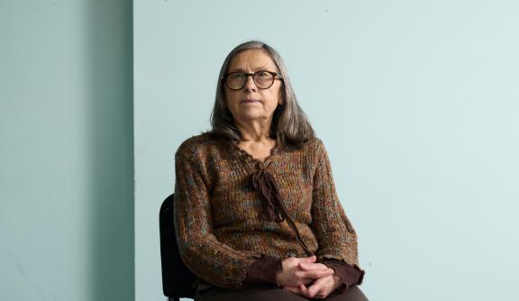 Older woman smiling at camera while sitting down